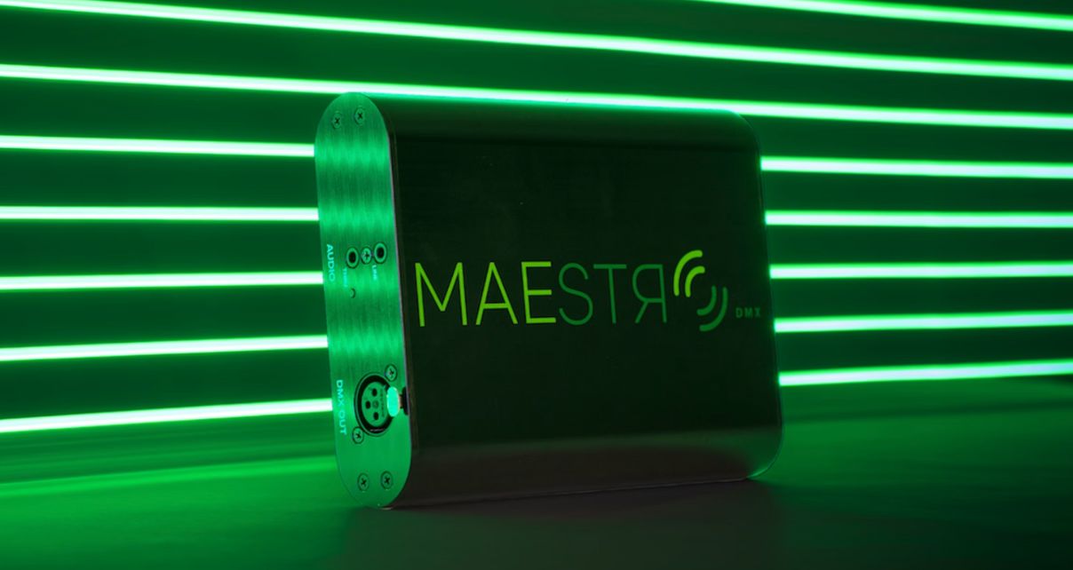 Tiny black Maestro DMX device in front of green strips of light